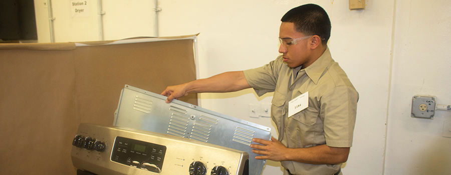 Appliance repair technician dismantling and reassembling appliance to make a diagnosis