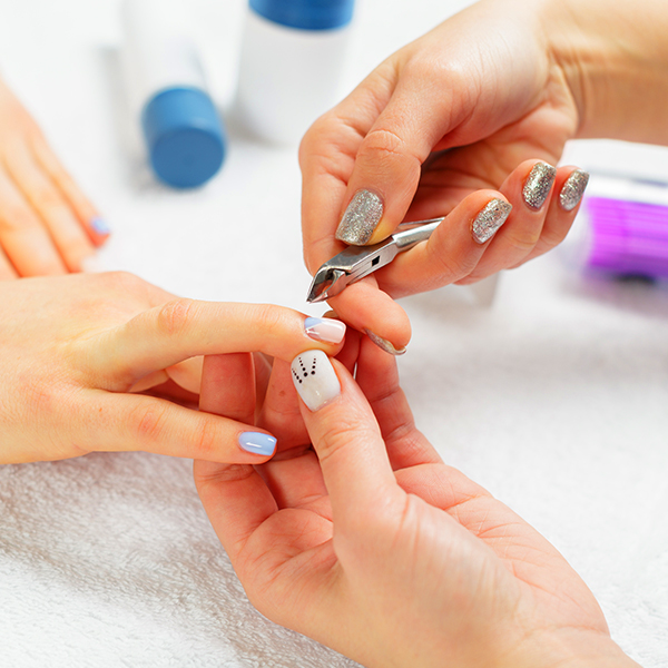Nail Technician cleaning, cutting, shaping, and painting nails