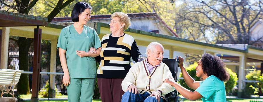 Aides helping senior patients walk and spend time outdoors